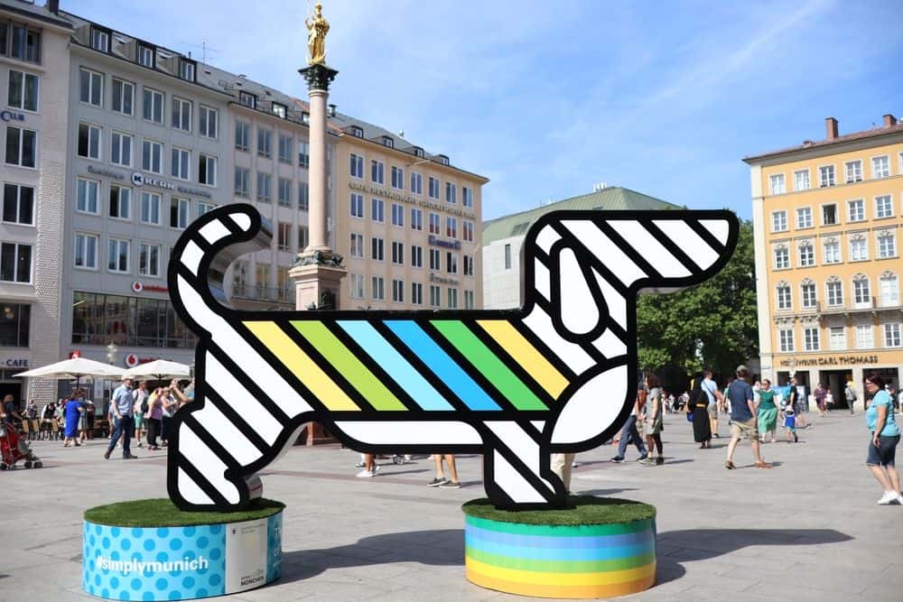 Colourful modern Dachshund sculpture with striped design displayed in Munich city square
